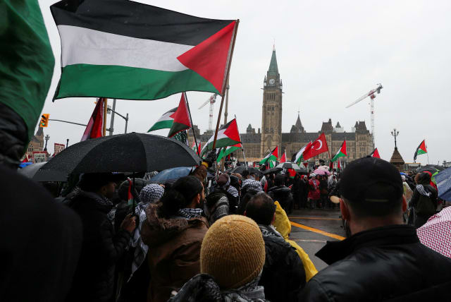 Protesters hold Palestinian flags during a rally to call for a ceasefire, amid the ongoing conflict between Israel and the Palestinian Islamist group Hamas in Gaza, on Parliament Hill in Ottawa, Ontario, Canada March 9, 2024.  (photo credit: REUTERS/Ismail Shakil)