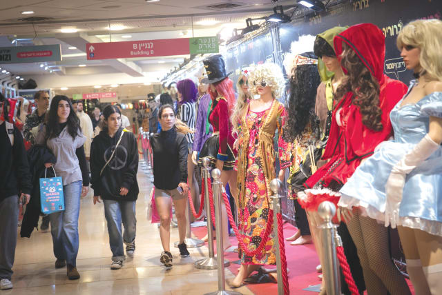  SHOPPERS LOOK at costumes on display at a shop in Tel Aviv, ahead of Purim. It isn’t the time for elaborate gatherings, parties or luxury vacations. Still, we can celebrate our redemptions of the past with the hope for redemption in the near future, says the writer.  (photo credit: MIRIAM ALSTER/FLASH90)