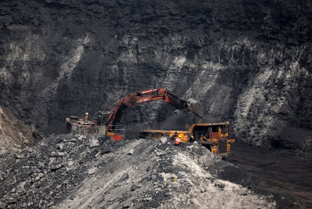  A loader loads coal in the truck at an open cast coal field at Topa coal mine in the Ramgarh district in the eastern Indian state of Jharkhand, India, February 27, 2024. (photo credit: REUTERS/AMIT DAVE)