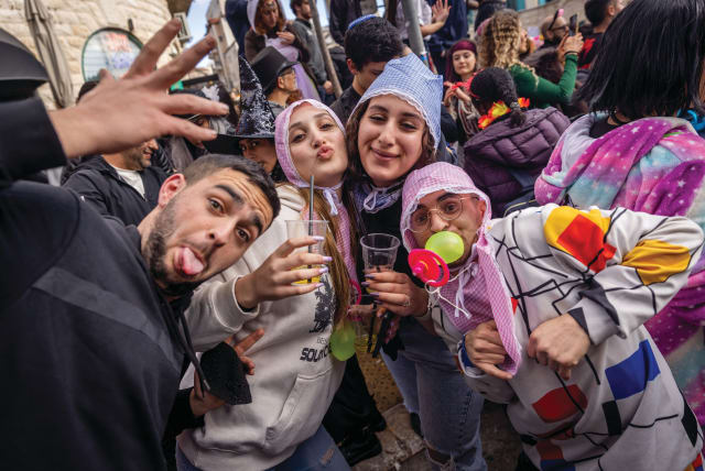  Purim revelers in Jerusalem's Nahlaot neighborhood in 2023. (photo credit: FLASH90)