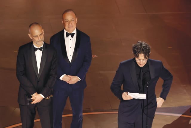  BRITISH-JEWISH FILMMAKER Jonathan Glazer (R) reads his Oscar acceptance speech in Hollywood, Mar. 10.  (photo credit: KEVIN WINTER/GETTY IMAGES)