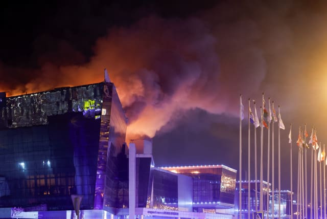 El humo se eleva sobre la sala de conciertos en llamas del Crocus City Hall después de un incidente de tiroteo reportado, en las afueras de Moscú, Rusia, el 22 de marzo de 2024. (crédito de la foto: MAXIM SHEMETOV/REUTERS)