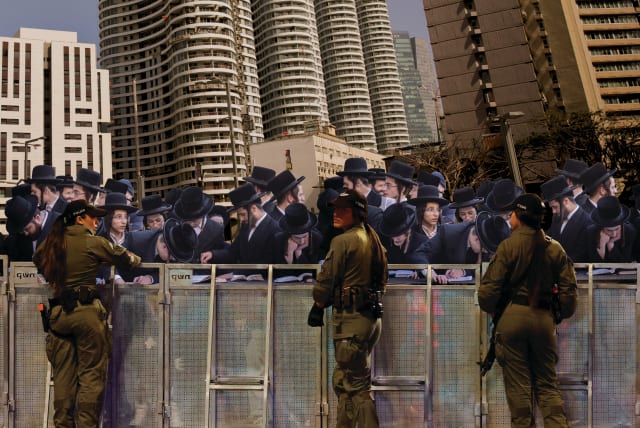  SECULAR IDF soldiers are seen being recruited by haredim in Tel Aviv for the battle on the Torah-front.  (photo credit: Reuters' Deli)