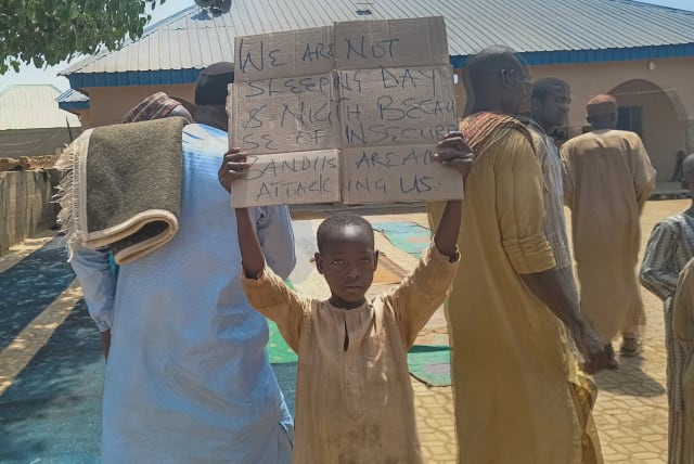  A boy holds a sign to protest against, what a teacher, local councilor and parents said, the kidnapping of hundreds school pupils by gunmen after the Friday prayer in Kaduna, Nigeria March 8, 2024.  (photo credit: REUTERS/STRINGER/FILE PHOTO)