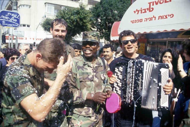  US soldiers celebrate Purim and the end of the Gulf War on the streets of Tel Aviv as children spray snow foam and Israelis play music. February 1991.  (photo credit: Alex Levac, IDF archive)