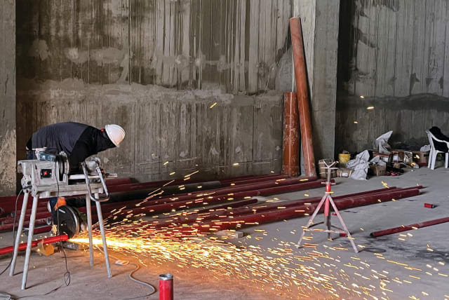  A WORKER uses a buzz saw at the construction site for a new warehouse in the Har Tuv Industrial Zone in Beit Shemesh earlier this month. To invest in Israel, you used to have to be a Zionist. Now, you only need to be a capitalist, says the writer. (photo credit: REUTERS/Ari Rabinovitch)