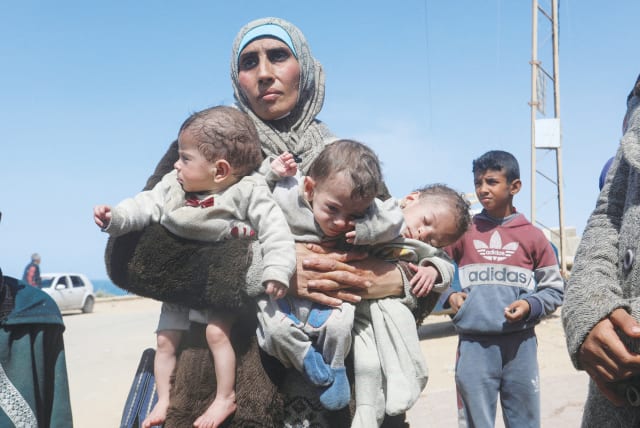  A PALESTINIAN WOMAN flees with her triplet children from the area of Shifa Hospital, moving southward in the Gaza Strip, last week.  (photo credit: REUTERS/Ramadan Abed)
