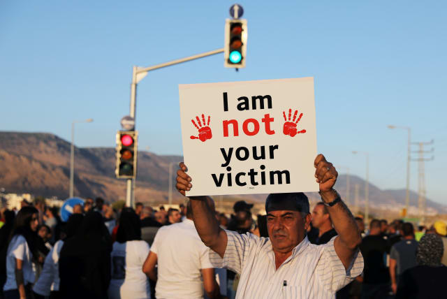  A man holds a placard during a protest against what Israeli Arabs citizens claim is Israeli police inaction to the violent crimes in their towns, in Majd al-Krum, northern Israel October 3, 2019.  (photo credit: AMMAR AWAD/REUTERS)