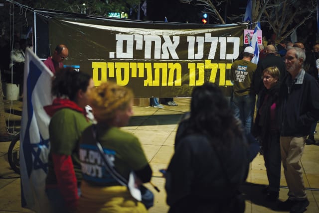  A poster at a Tel Aviv protest reads in Hebrew, "We are all brothers. We are all drafted." (photo credit: ERIK MARMOR/FLASH90)