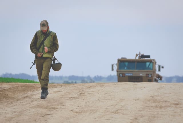  A SOLDIER walks near an IDF Artillery Corps staging area on the  border with Gaza (photo credit: MOSHE SHAI/FLASH90)