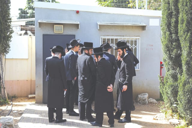  Ultra-Orthodox men line up at an IDF draft office to process their exemptions from mandatory military service. (photo credit: HANNAH MCKAY/ REUTERS)