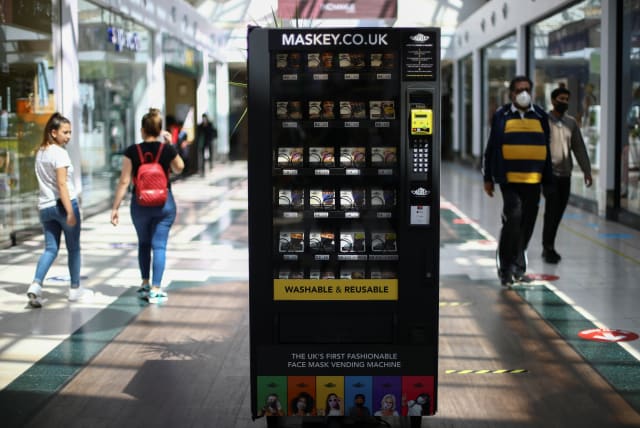 A vending machine that sells protective masks is seen in a shopping centre, following the coronavirus disease (COVID-19) outbreak, in Ilford, London, Britain July 29, 2020.  (photo credit: Hannah McKay/Reuters)