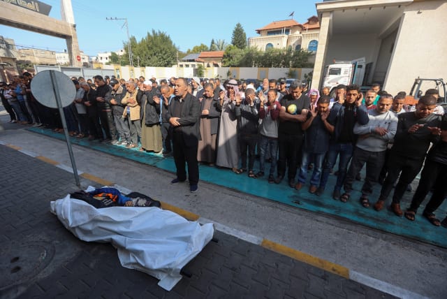  Mourners offer funeral prayers next to the body of Palestinian Issam Abu Taha, a worker from the World Central Kitchen (WCK), who was killed in an Israeli airstrike. (photo credit: REUTERS/AHMED ZAKOT)