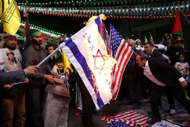 Protesters burn US and Israeli flags during an anti-Israel protest in Tehran, Iran, April 1, 2024 (photo credit: MAJID ASGARIPOUR/WANA (WEST ASIA NEWS AGENCY) VIA REUTERS)