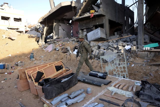  An Israeli soldier walks next to items found inside a workshop which they claim was used for weapon production and located on the lower floors of a residential building in the northern Gaza Strip, November 8, 2023. (photo credit: RONEN ZVULUN/REUTERS)