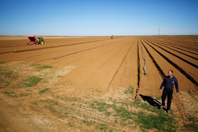 Israeli farmer Elad Katzir walks in his field near the border with the southern Gaza Strip, in Nir Oz, Israel January 11, 2018. (photo credit: AMIR COHEN/REUTERS)