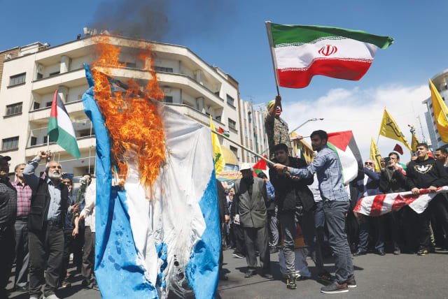  IRANIANS BURN an Israeli flag during a rally, in Tehran on Friday, al-Quds Day. The veneer of aggression which the Iranian government projects increasingly appears to be more a facade than a reflection of genuine strength, the writer argues. (photo credit: WEST ASIA NEWS AGENCY/REUTERS)