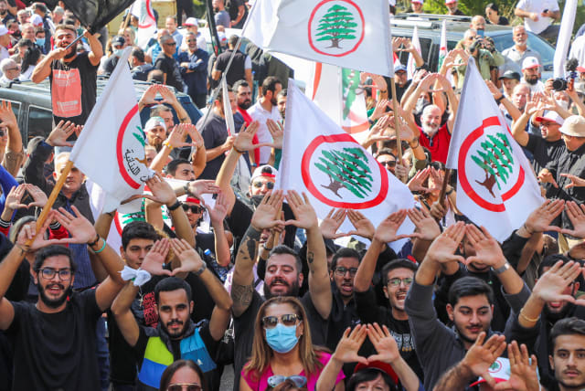  Supporters of the Christian Lebanese Forces party gesture during a protest against the summoning of the party leader Samir Geagea for a hearing by army intelligence over this month's Beirut street violence, in Maarab, Lebanon October 27, 2021. (photo credit: MOHAMED AZAKIR/REUTERS)