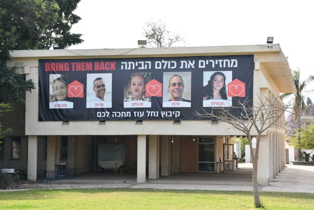  On Kibbutz Nahal Oz, a community center has a large banner calling to bring the hostages home. Seven people were kidnapped from the community, and five have returned. (photo credit: SETH J. FRANTZMAN)