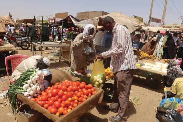  A MAN buys vegetables from a local vendor during the month of Ramadan in Omdurman, Sudan. Nearly 20 million people, almost one out of every two Sudanese, are facing acute food insecurity in a country that used to be a major food producer, the writers note. (photo credit: EL TAYEB SIDDIG/REUTERS)