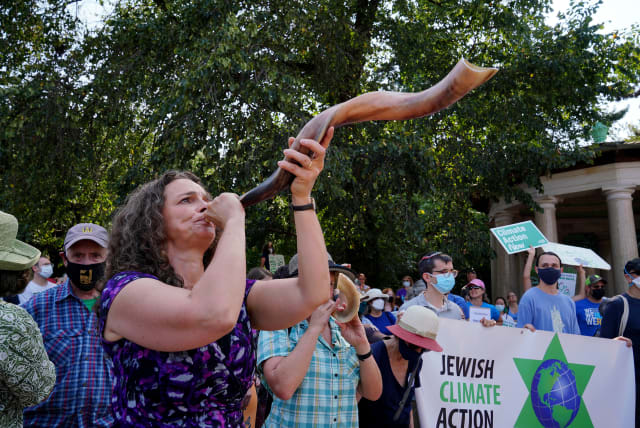  Rabbi Jennie Rosenn blows the shofar at the "Jewish Climate Action, Hear The Call Senator Schumer" event in New York City on September 12, 2021. (photo credit: Jemal Countess / Getty, courtesy of Dayenu)