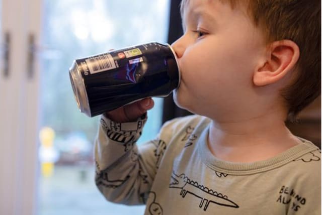  A young child drinking a sugary, fizzy beverage. (photo credit: Swansea University )