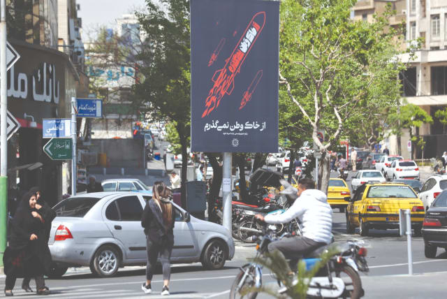  PEOPLE PASS by an anti-Israel poster on a street in Tehran, yesterday.  (photo credit: WEST ASIA NEWS AGENCY/REUTERS)