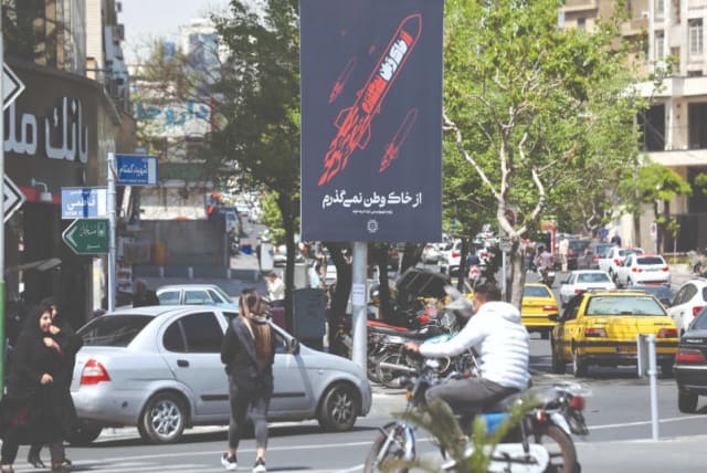  La gente pasa ayer junto a un cartel antiisraelí en una calle de Teherán. (photo credit: WEST ASIA NEWS AGENCY/REUTERS)