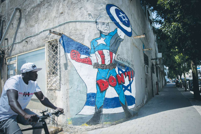 A MURAL in Tel Aviv depicts US President Joe Biden as a superhero defending Israel against the Iranian attack. On the strategic level, Israel suffered a whopping loss as Iran pierced American and Israeli deterrence frameworks with apparent impunity, the writer maintains. (photo credit: MIRIAM ALSTER/FLASH90)