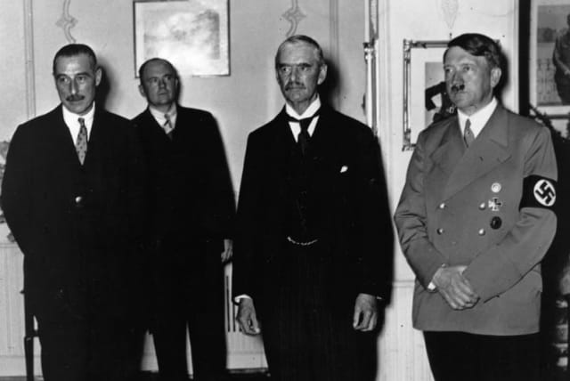  El PRIMER MINISTRO BRITÁNICO Neville Chamberlain (segundo por la derecha) con Adolf Hitler en Múnich en septiembre de 1938 durante la firma del Pacto de Múnich, que accedía a la exigencia de Hitler de que los Sudetes fueran cedidos a Alemania. (photo credit: Photo by Keystone/Getty Images)