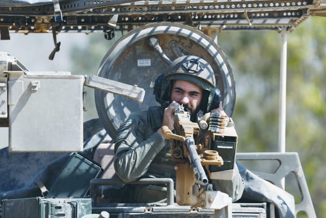  AN IDF soldier on a military vehicle near the Gaza border last week; The low ratio of civilian-to-combatant deaths is noteworthy as the war is fought in dense urban areas where civilians have little protection, and Hamas fighters are protected in underground tunnels, says the writer. (photo credit: AMIR COHEN/REUTERS)