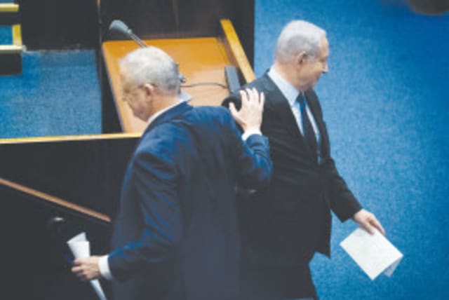 El PRIMER MINISTRO Benjamin Netanyahu y el líder del Partido Azul y Blanco, Benny Gantz, se cruzan en la Knesset el año pasado. (photo credit: YONATAN SINDEL/FLASH90)