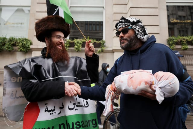  Jewish anti-zionist shakes hands with a pro-Palestinian demonstrator as people gather during a march in solidarity with Palestinians in Gaza, amid the ongoing conflict between Israel and the Palestinian Islamist group Hamas, in London, Britain, April 27, 2024 (photo credit: REUTERS/HOLLIE ADAMS)
