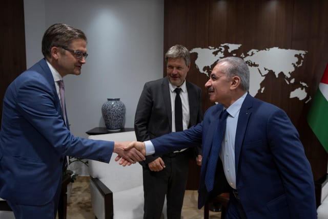  Palestinian Prime Minister Mohammad Shtayyeh shakes hands with the Head of Representative Office of the Federal Republic of Germany in the Palestinian territories, Oliver Owcza, while he receives German Vice-Chancellor Robert Habeck, at his office in the West Bank city of Ramallah, June 7, 2022. (photo credit: VIA REUTERS)