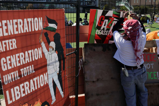  A person hangs a sign at a protest encampment in support of Palestinians, amid the ongoing conflict between Israel and the Palestinian Islamist group Hamas, at the University of British Columbia (UBC) in Vancouver, British Columbia, Canada, April 29, 2024. (photo credit: REUTERS/CHRIS HELGREN)
