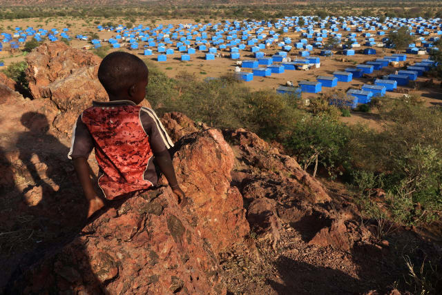  A boy sits atop a hill overlooking a refugee camp near the Chad-Sudan border, November 9, 2023. Hundreds of Masalit families from Sudan's West Darfur state were relocated here months after fleeing to the Chadian border town of Adre, following an ethnically targeted massacre in El Geneina. (photo credit: REUTERS/EL TAYEB SIDDIG)