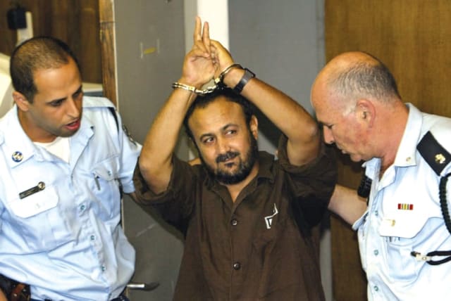  MARWAN BARGHOUTI es conducido al tribunal por la policía para la vista de su juicio en mayo de 2004, en la que fue condenado por cinco cargos de asesinato en atentados terroristas. (photo credit: David Silverman/Reuters)