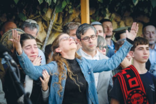 SARIT ZUSSMAN y otros familiares y amigos lloran la muerte del sargento de primera clase (res.) Ben Zussman en su funeral en el cementerio militar de Monte Herzl, en Jerusalén, en diciembre, tras morir en la operación terrestre de las FDI en Gaza. (photo credit: Arie Leib Abrams/Flash90)