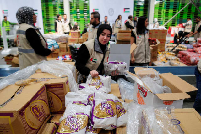 Voluntarios de la Media Luna Roja de los Emiratos preparan paquetes con ayuda humanitaria para Gaza que serán transferidos a través del paso fronterizo de Rafah entre Egipto y la Franja de Gaza, en El Cairo, Egipto, el 30 de marzo de 2024. (photo credit: REUTERS/SHOKRY HUSSEIN)