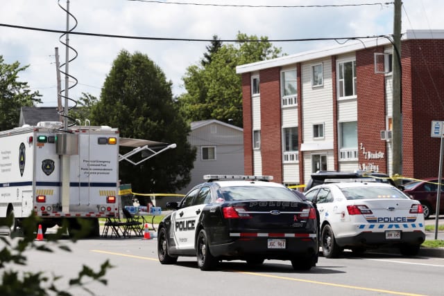  Fredericton Police and Royal Canadian Mounted Police (RCMP) investigate apartment complex which was the scene of a shooting incident in Fredericton, New Brunswick, Canada August 10, 2018. (photo credit: REUTERS/Dan Culberson)