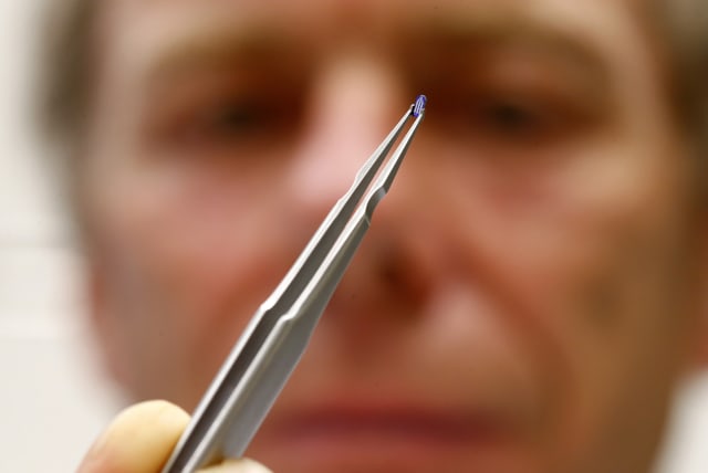  Physicist Urs Duerig uses tweezers to hold a silicon tip with a sharp apex, 100,000 times smaller than a sharpened pencil, of a prototype of an IBM NanoFrazor 3D nano printing tool at a laboratory of IBM Research in Rueschlikon, near Zurich April 23, 2014.  (photo credit: Arnd Wiegmann/Reuters)