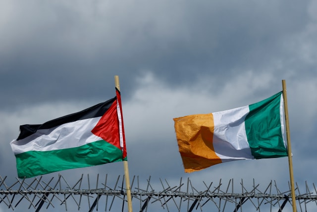 Banderas de Palestina e Irlanda ondean una junto a la otra sobre el Muro Internacional en apoyo a Gaza, en medio del actual conflicto entre Israel y el grupo islamista palestino Hamás, en Belfast, Irlanda del Norte, 29 de marzo de 2024. (photo credit: Clodagh Kilcoyn/Reuters)