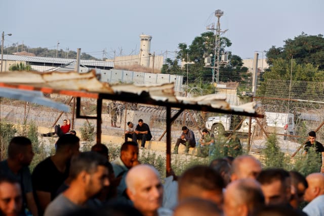  Palestinian workers at an Israeli checkpoint in Tulkarm, West Bank, August 21, 2022.  (photo credit: REUTERS/RANEEN SAWAFTA)