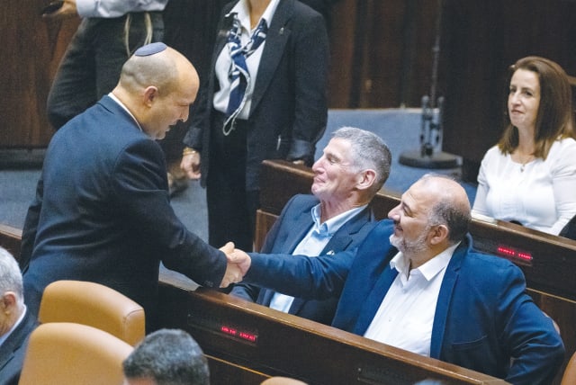  THEN-PRIME MINISTER Naftali Bennett shakes hands with Ra’am Party leader Mansour Abbas in the Knesset plenum, in 2021. (photo credit: OLIVIER FITOUSSI/FLASH90)
