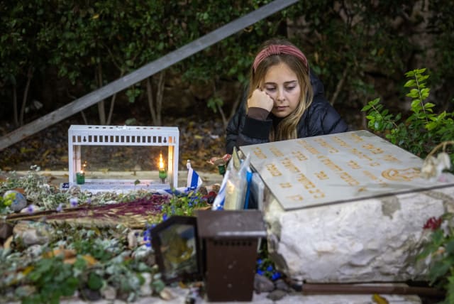 SENAI GUEDALIA, widow of soldier Yosef Malachi Guedalia who was killed in the Kfar Aza area on October 7, marks her late husband’s 24th birthday and lights the first Hanukkah candle at his grave, at Mount Herzl Military Cemetery in Jerusalem on Wednesday. 