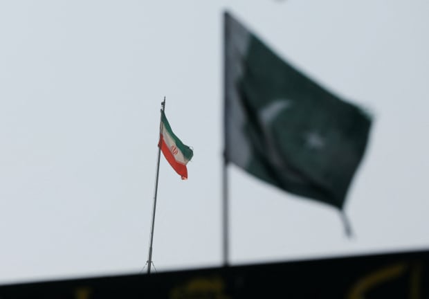 The flag of Iran is seen over its consulate building, with Pakistan's flag in the foreground, January 18, 2024.