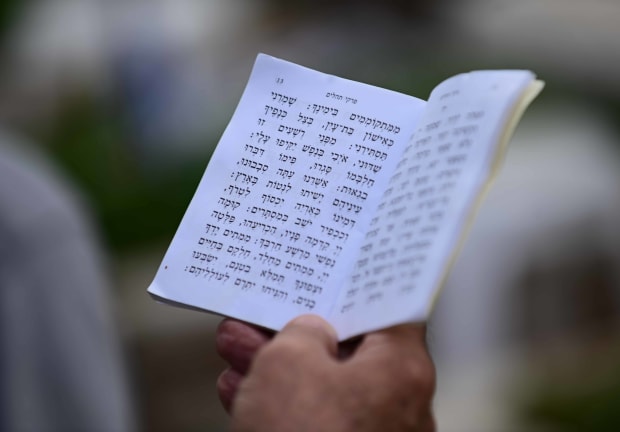 A Jewish person holds Tehillim, the book of Psalms, seeking solace in prayer on Memorial Day in Tel Aviv