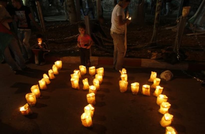 Palestinians lay out candles at a rally in Ramallah GAL