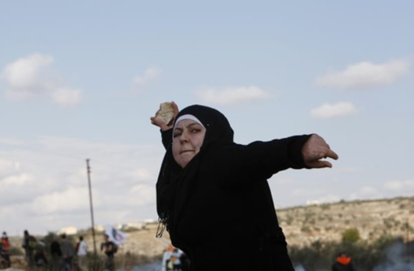 Palestinian woman throws stone at Israeli soldiers 465 R
