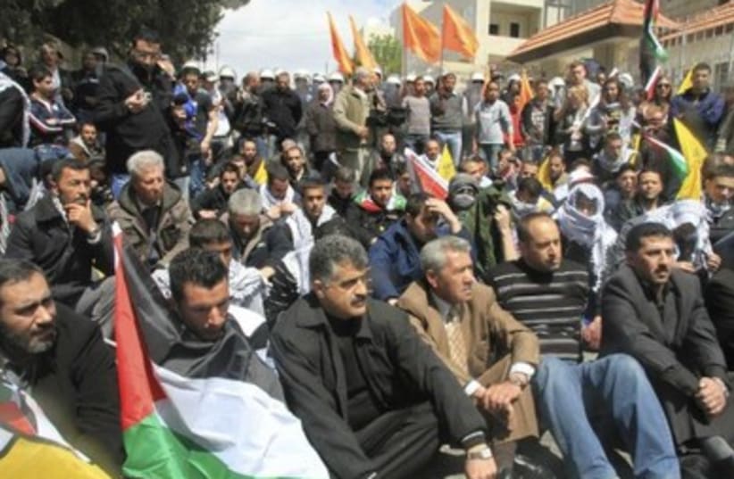Palestinian protesters sitting in road near Bethlehem